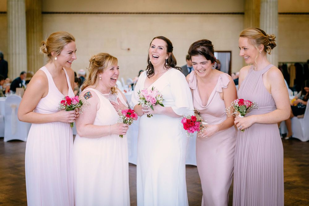 A Bride and her Bridesmaids laugh enthusiastically inside the Coal Exchange Hotel, Cardiff